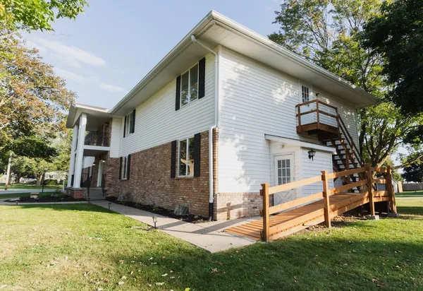 a view of a white house with a yard and sitting area