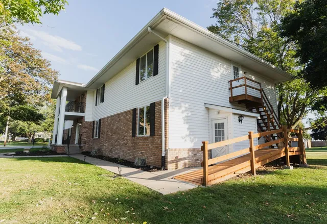 a view of a white house with a yard and sitting area