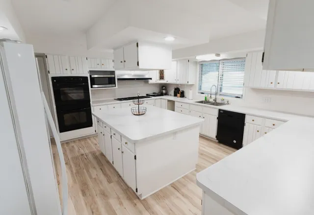 a kitchen with stainless steel appliances a white cabinets and refrigerator