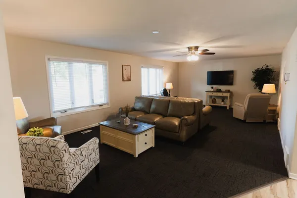a living room with furniture ceiling fan and a window