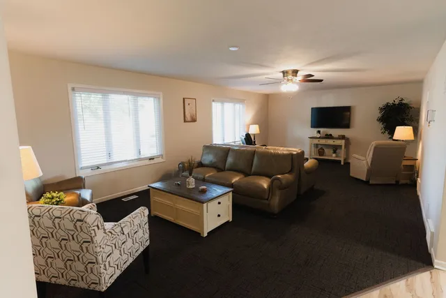a living room with furniture ceiling fan and a window