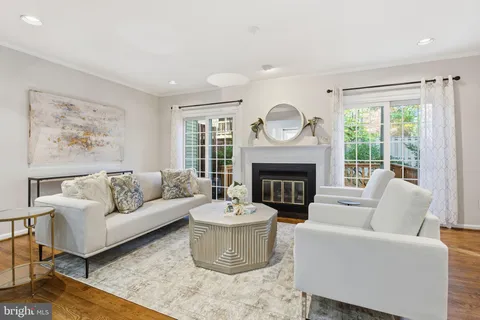 a living room with furniture a fireplace and a large window