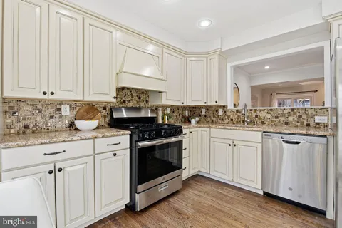 a kitchen with granite countertop white cabinets and white appliances