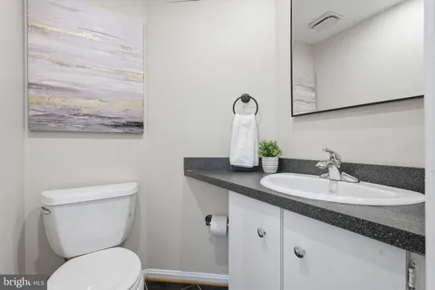 a bathroom with a granite countertop toilet sink and mirror