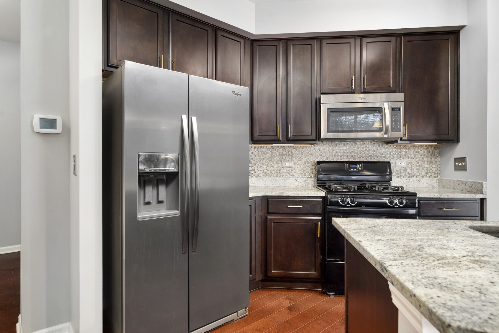 2900 Church Road Aurora, IL 60502 - Photo 3 of 15 a kitchen with kitchen island granite countertop stainless steel appliances and wooden cabinets
