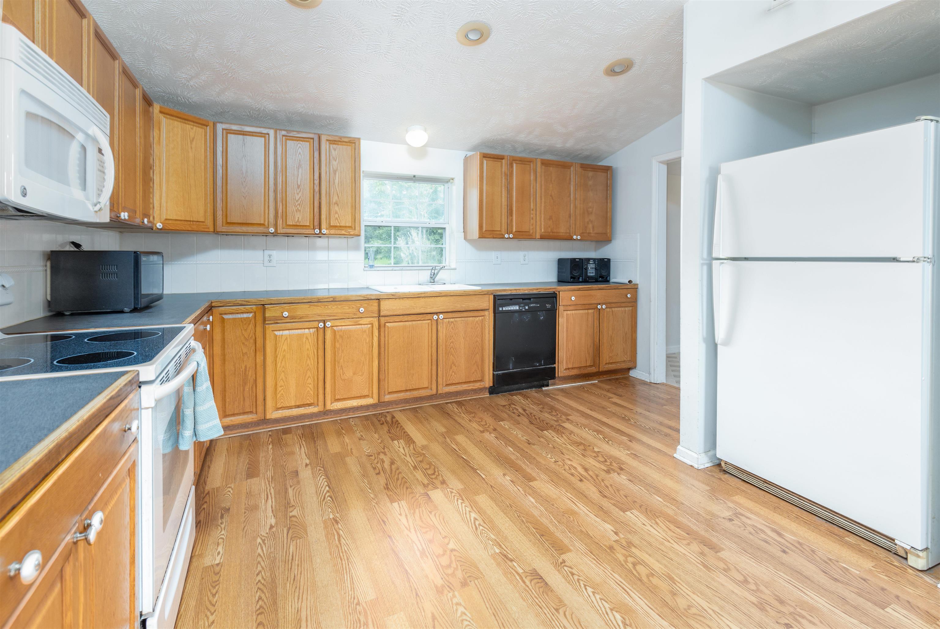 5715 Monroe Smith Road Jacksonville, FL 32210 - Photo 4 of 23 a kitchen with granite countertop a refrigerator stove top oven and sink