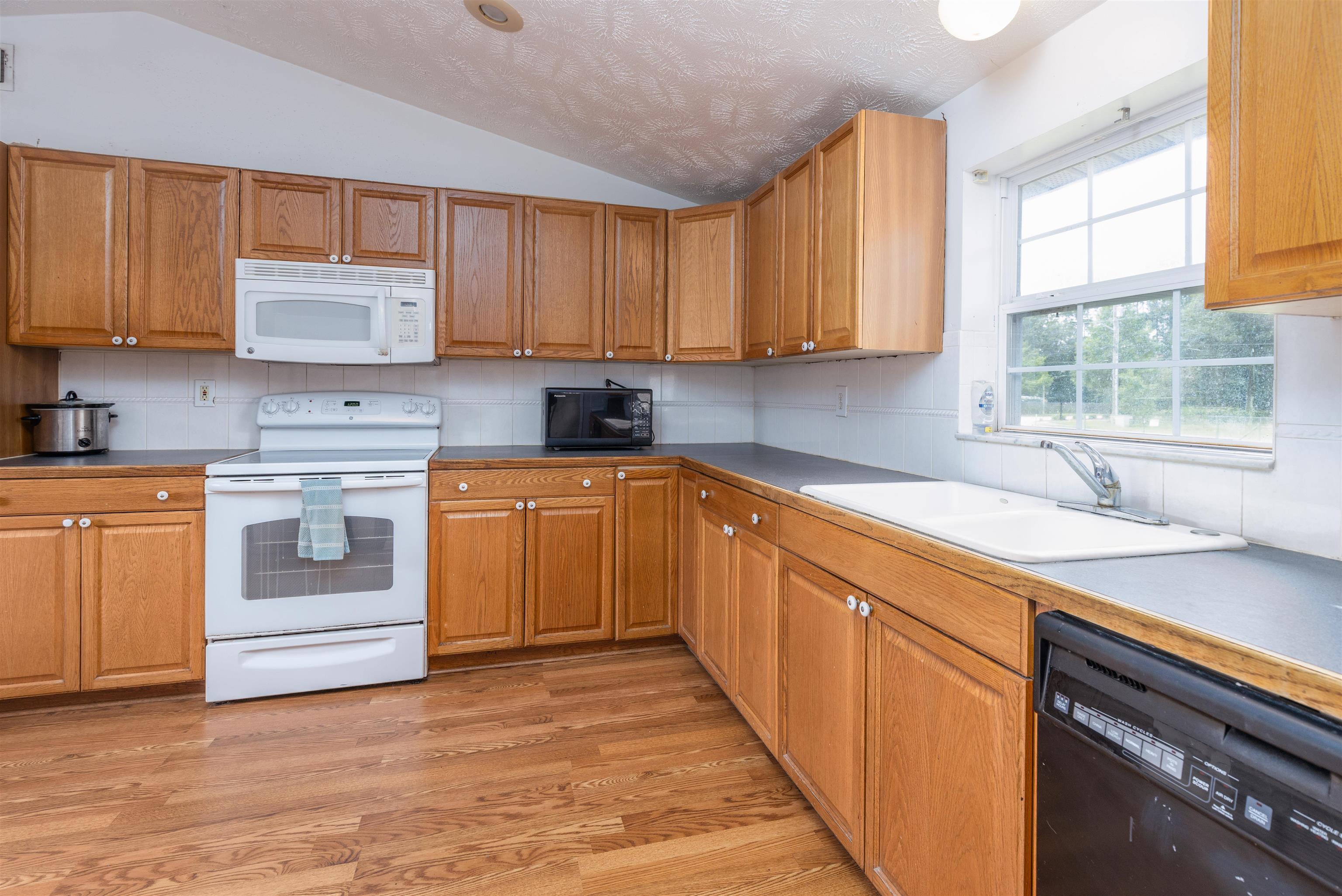 5715 Monroe Smith Road Jacksonville, FL 32210 - Photo 5 of 23 a kitchen with a white stove top oven sink and cabinets