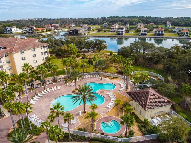 an aerial view of residential houses with outdoor space and lake view