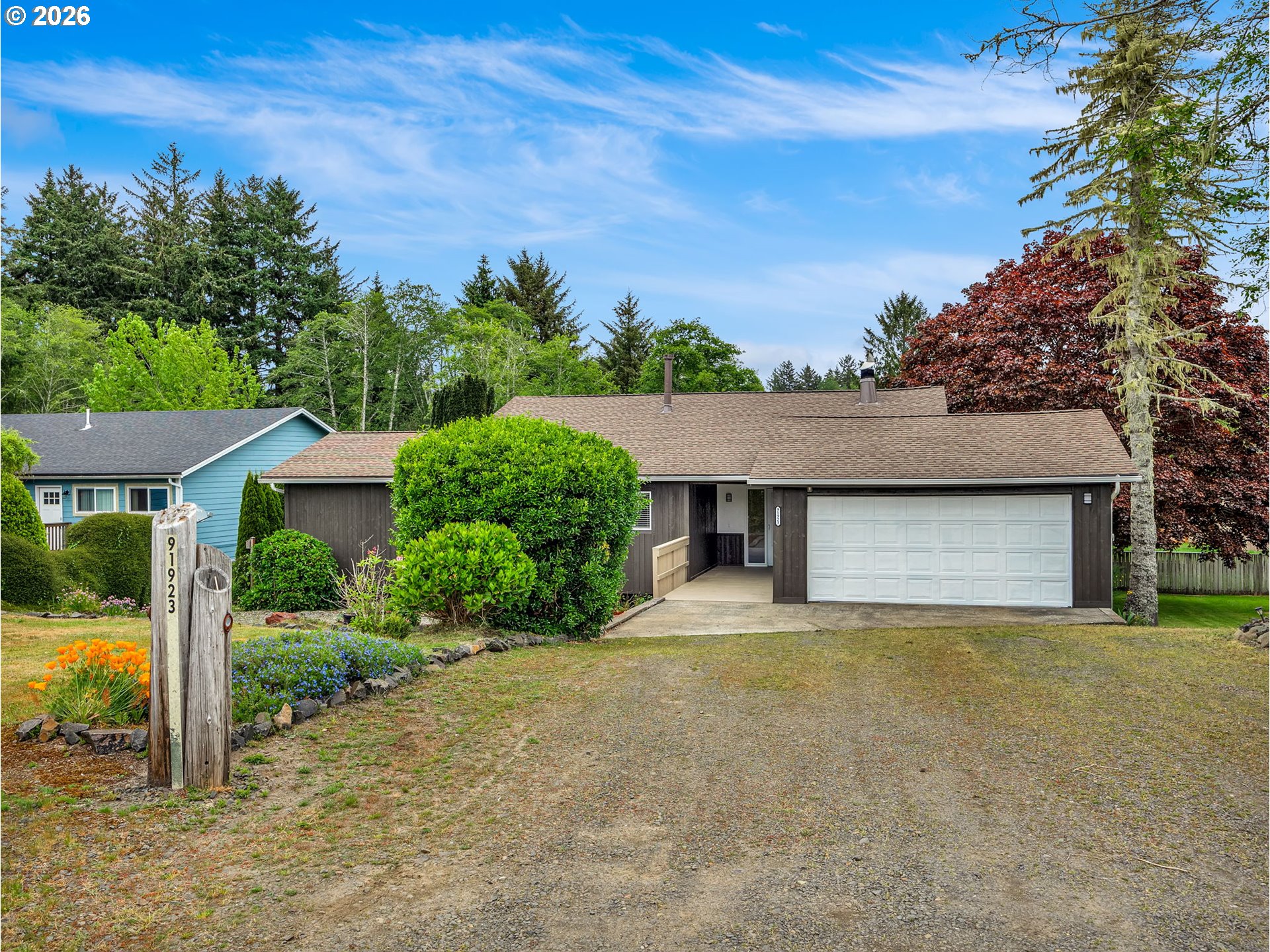 91923 Ridge Road Warrenton, OR 97146 - Photo 1 of 35 a front view of a house with a yard and garage