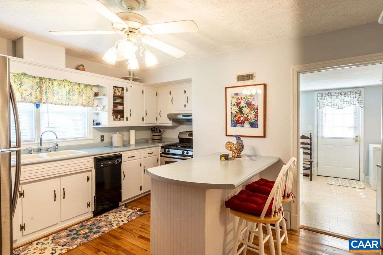 1830 Hunters Lodge Road Palmyra, VA 22963 - Photo 7 of 32 a open kitchen with stainless steel appliances a sink dishwasher a stove a dining table and chairs with wooden floor
