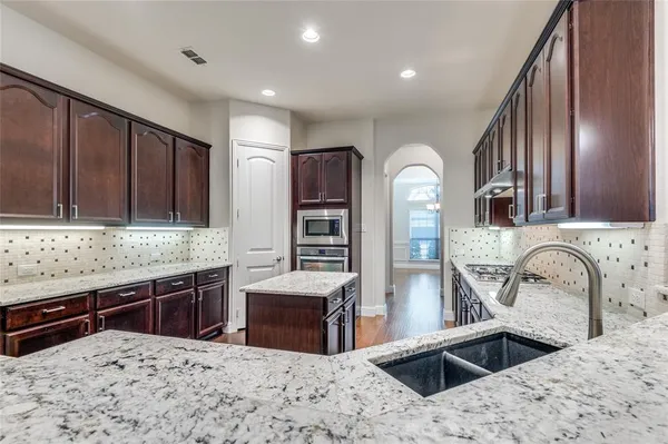 a kitchen with stainless steel appliances kitchen island granite countertop a sink and cabinets