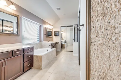 a spacious bathroom with a shower sink and mirror