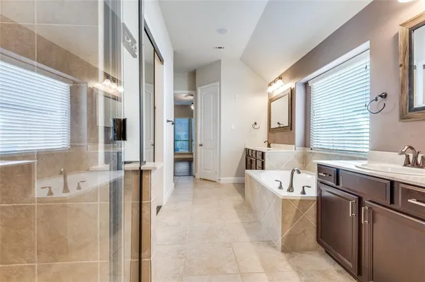 a large bathroom with a tub a sink and a large mirror
