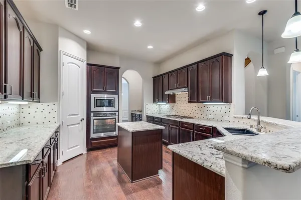 a kitchen with stainless steel appliances granite countertop a sink stove and refrigerator