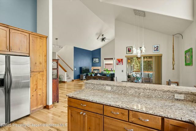 a view of living room with granite countertop cabinets and refrigerator