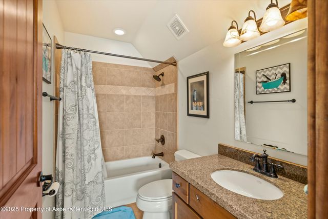 a bathroom with a granite countertop sink toilet tub and shower