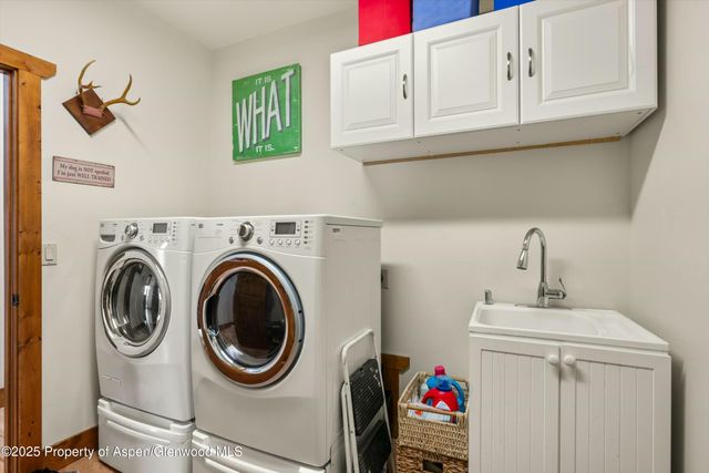 a utility room with sink dryer and washer