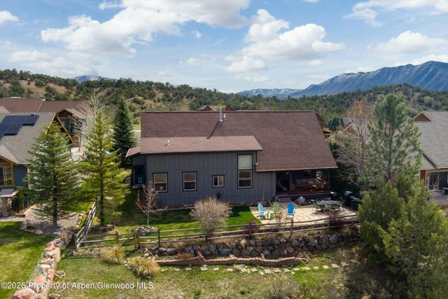 an aerial view of a house with a garden and lake view