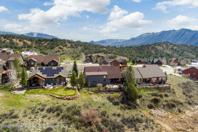 an aerial view of residential houses with outdoor space and trees