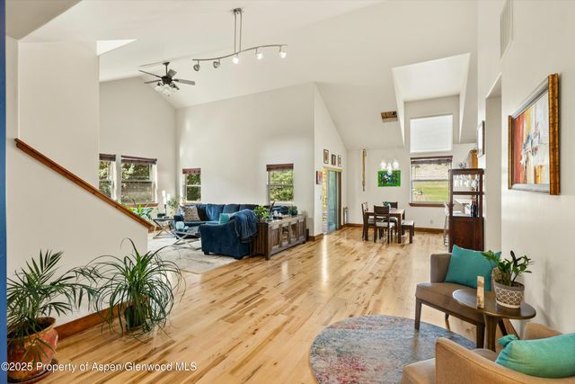 a living room with furniture kitchen view and a large window