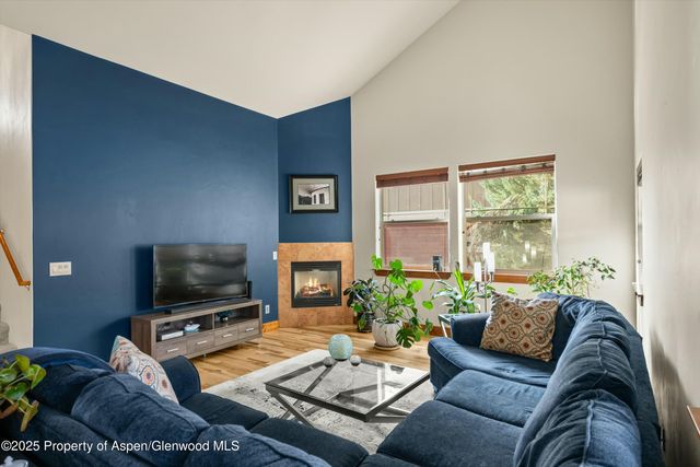 a living room with furniture a flat screen tv and a window