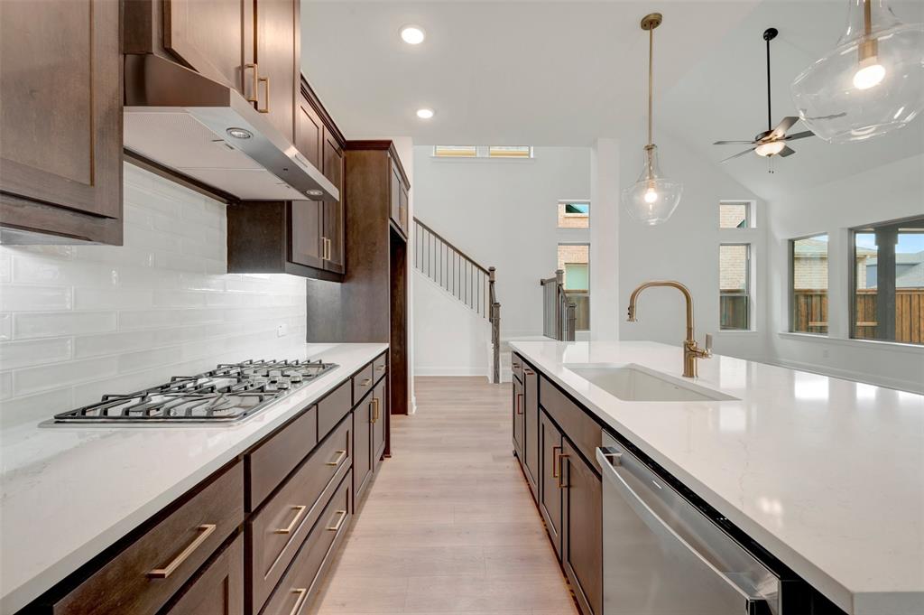 1908 Cola Drive Van Alstyne, TX 75495 - Photo 17 of 29 Gourmet kitchen with dark wood cabinetry, white quartz countertops, subway tile backsplash, and stainless steel appliances