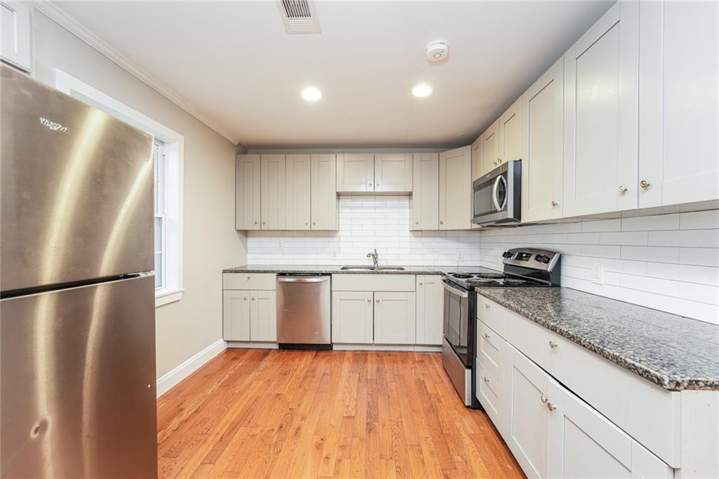 528 Newlin Court Lawrenceville, GA 30046 - Photo 13 of 30 a kitchen with a refrigerator and white cabinets