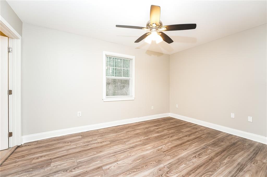 528 Newlin Court Lawrenceville, GA 30046 - Photo 14 of 30 an empty room with wooden floor fan and windows