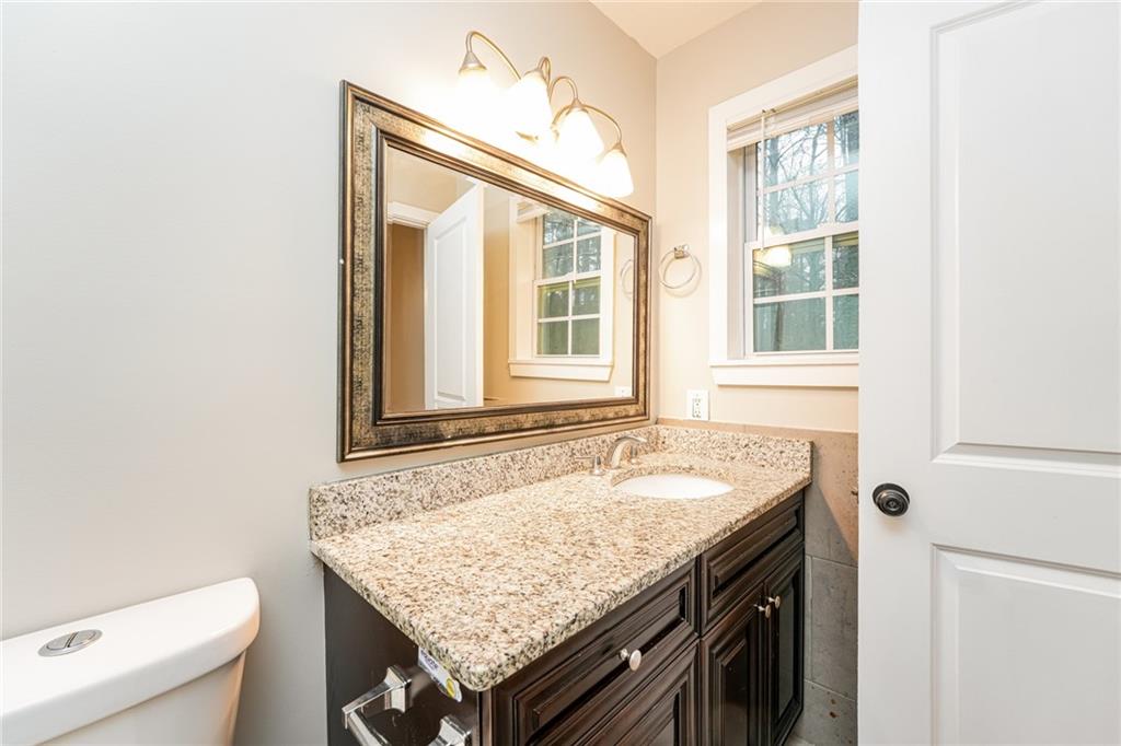 528 Newlin Court Lawrenceville, GA 30046 - Photo 17 of 30 a bathroom with a granite countertop sink and a toilet