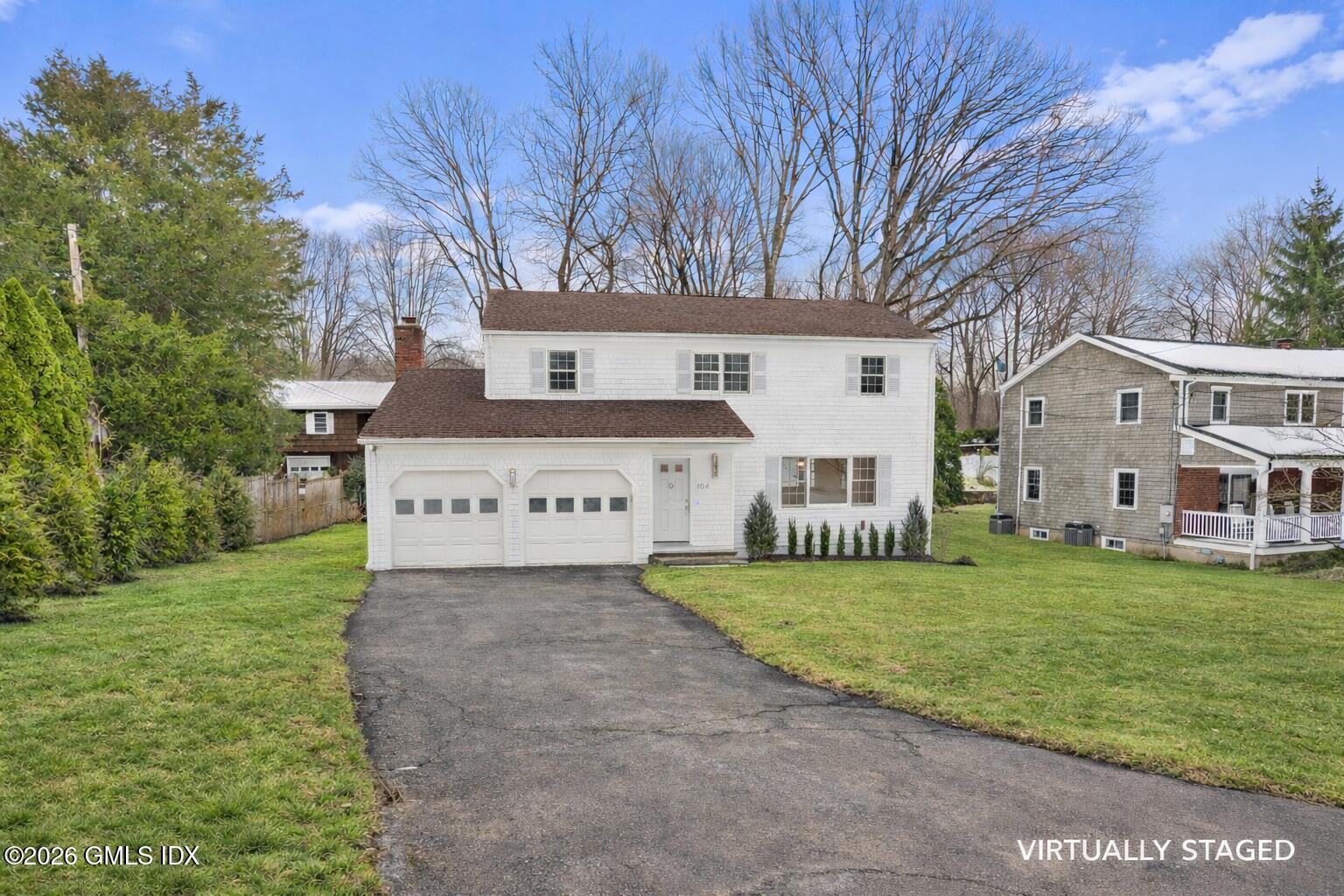 a view of a house with a big yard and large trees