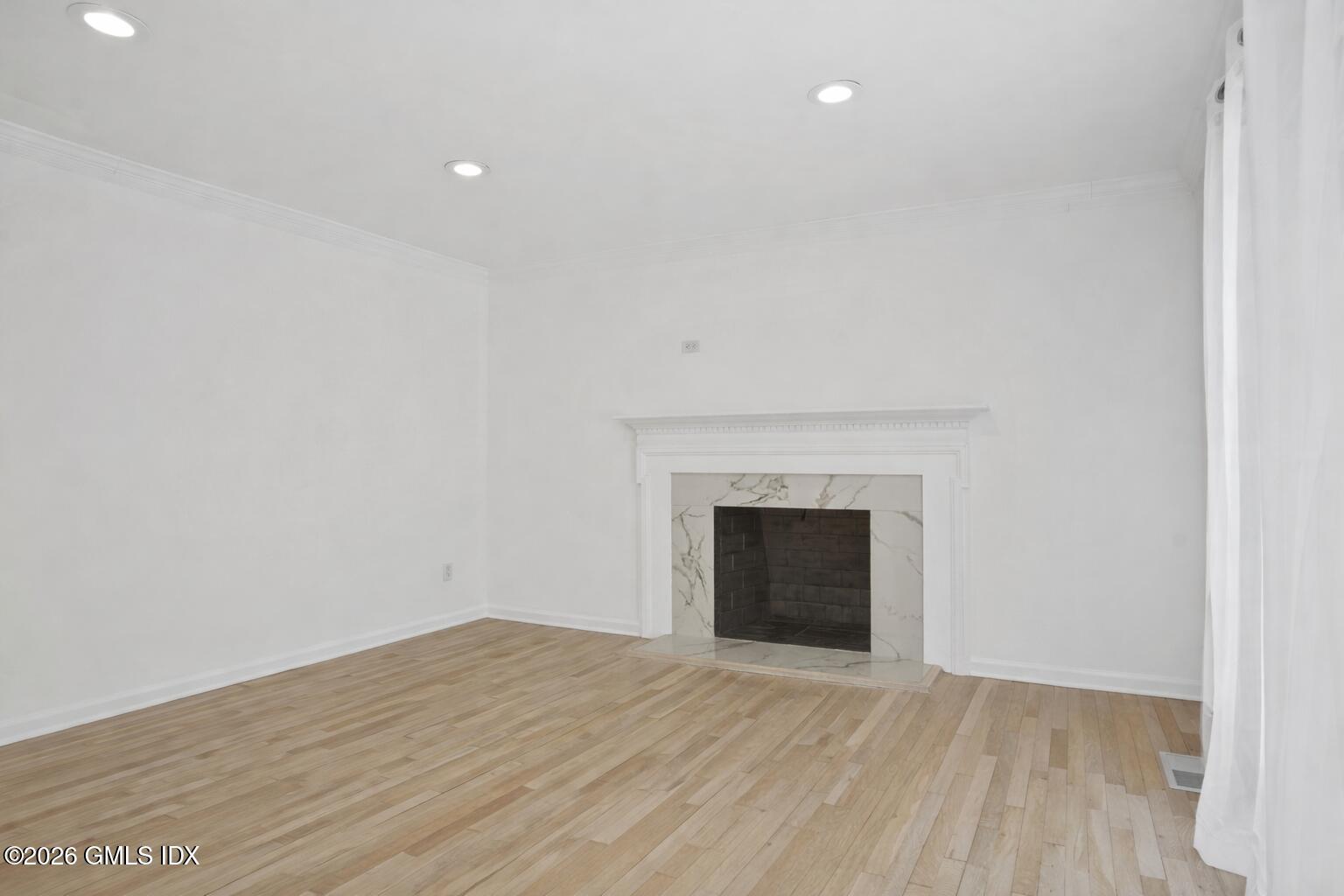 104 Hillcrest Park Road Cos Cob, CT 06807 - Photo 13 of 25 a view of empty room with wooden floor and fireplace