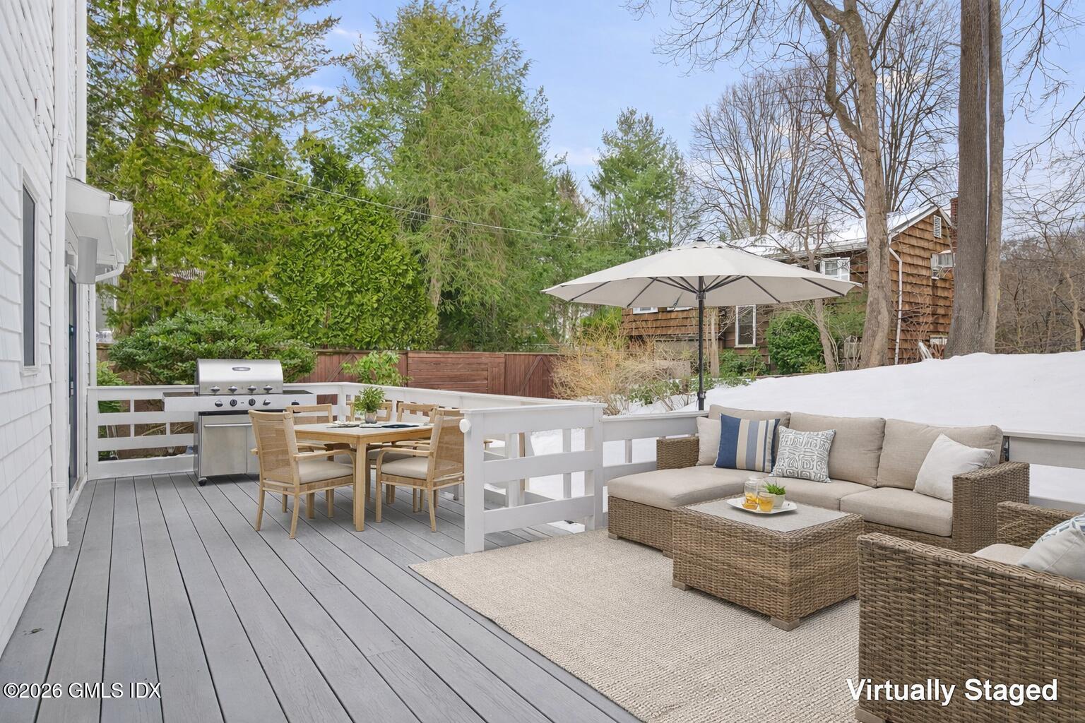 104 Hillcrest Park Road Cos Cob, CT 06807 - Photo 24 of 25 a view of a patio with a dining table and chairs under an umbrella with a barbeque