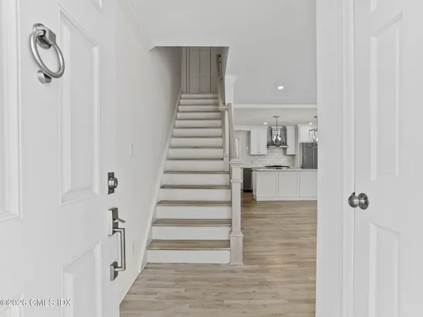 a view of entryway and hall with wooden floor