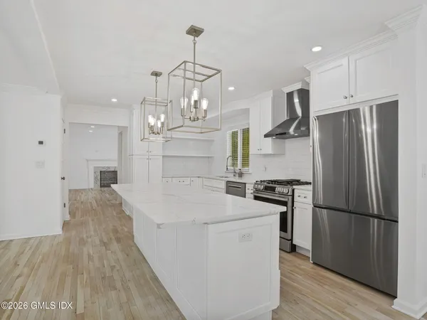 a kitchen with stainless steel appliances granite countertop a refrigerator a stove and a sink