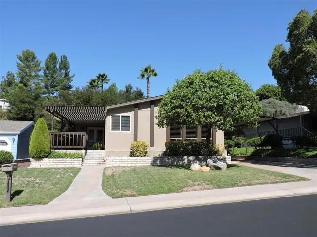 a front view of a house with a yard and potted plants