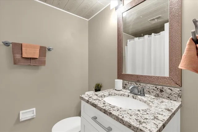 a bathroom with a granite countertop sink and a mirror