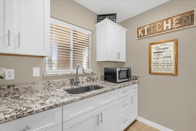 a kitchen with stainless steel appliances granite countertop a sink and a microwave