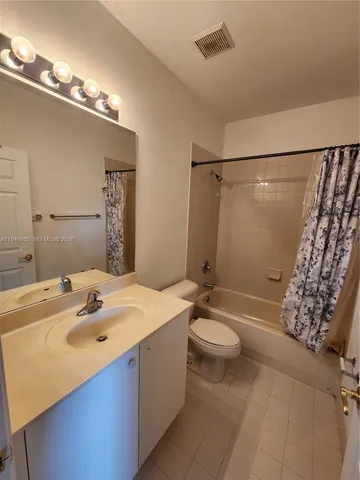 a bathroom with a sink a toilet a mirror and shower