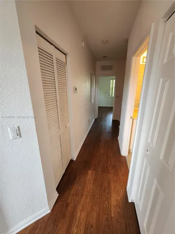 a view of a hallway with wooden floor and stairs