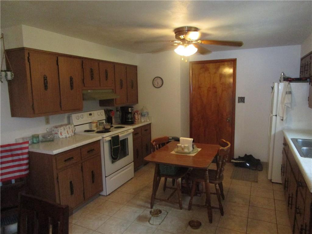 112 State Hill Road Smithton, PA 15479 - Photo 6 of 25 a kitchen with a table chairs refrigerator and cabinets