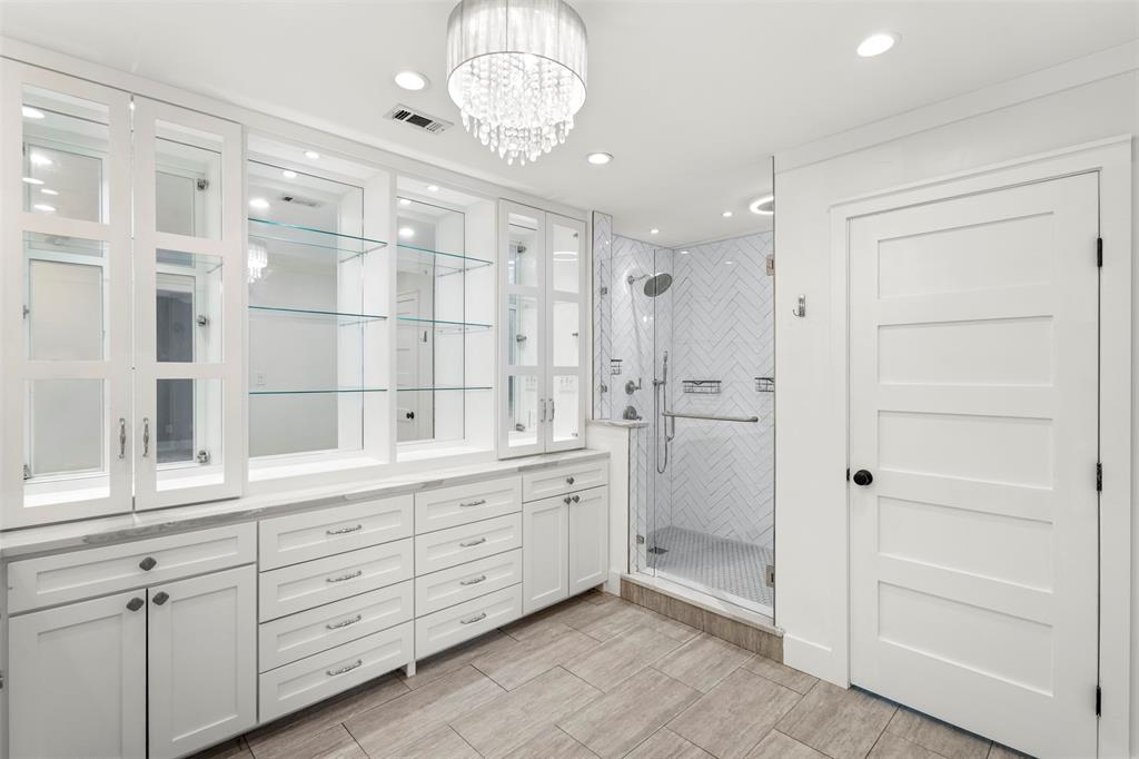 6754 Raymond Road Kaufman, TX 75142 - Photo 23 of 38 Spacious bathroom with extensive built-in white cabinetry, glass shelving, and light-toned countertops