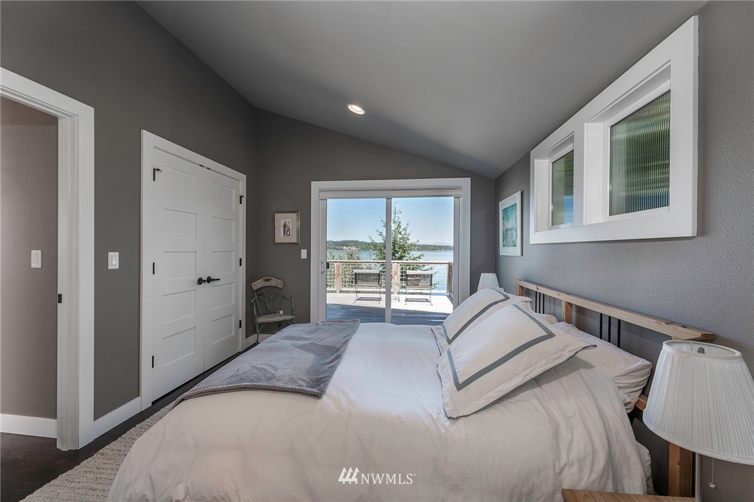 14301 Outer Bay Road Anderson Island, WA 98303 - Photo 15 of 40 a bedroom with a bed and a large window
