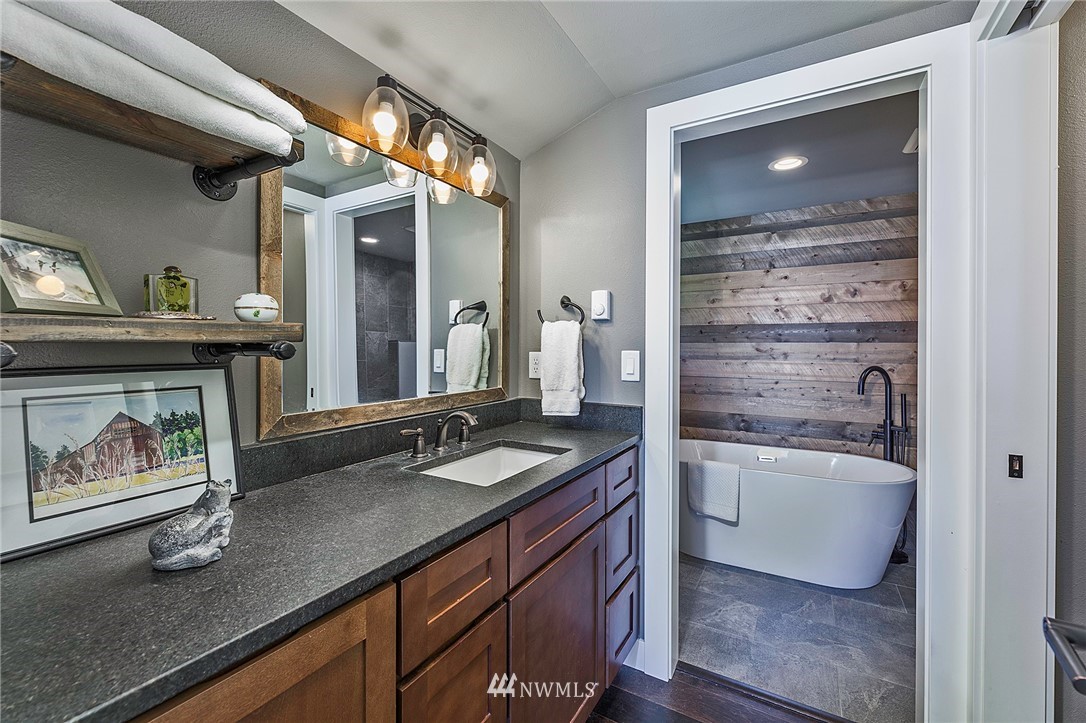 14301 Outer Bay Road Anderson Island, WA 98303 - Photo 16 of 40 a spacious bathroom with a granite countertop sink mirror and bathtub