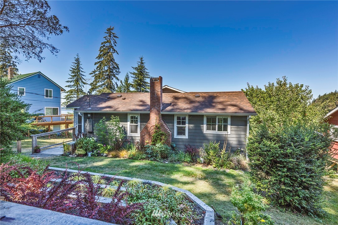 14301 Outer Bay Road Anderson Island, WA 98303 - Photo 5 of 40 a front view of a house with garden