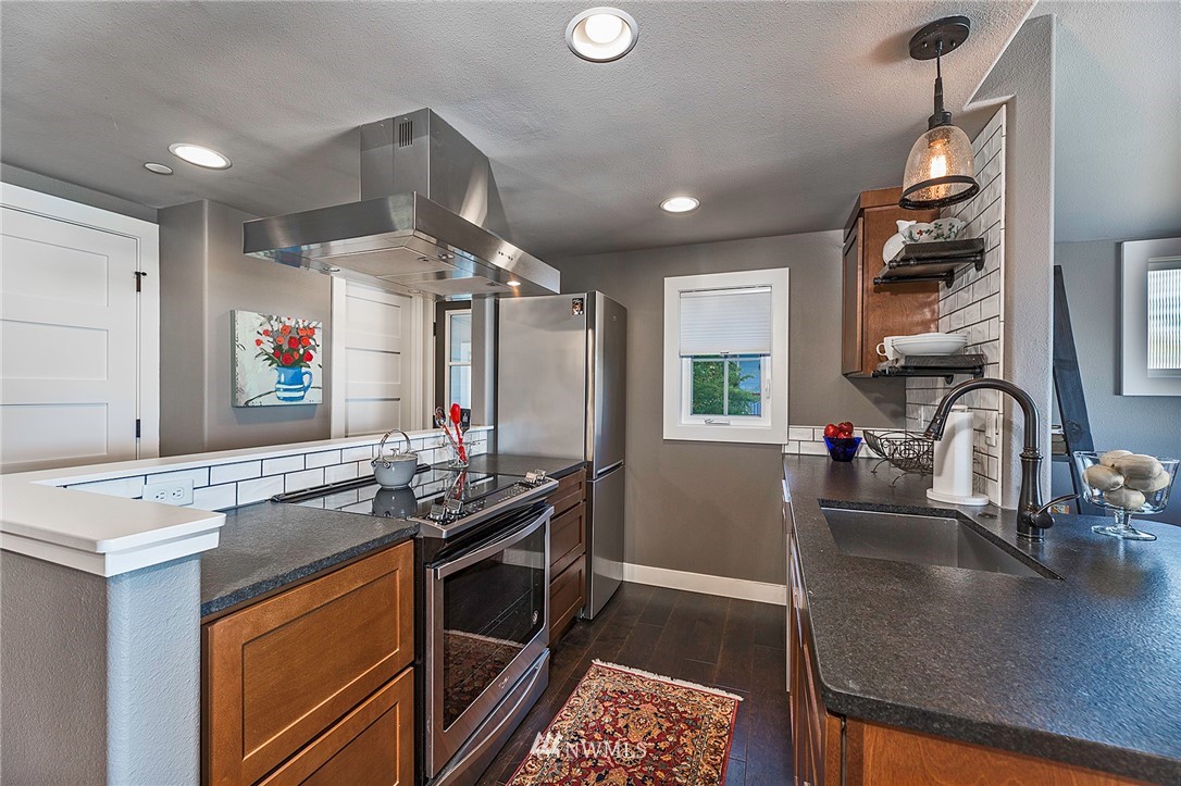 14301 Outer Bay Road Anderson Island, WA 98303 - Photo 8 of 40 a kitchen with stainless steel appliances granite countertop a sink and a stove