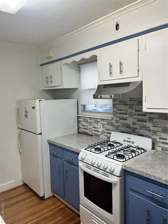 a white stove top oven sitting inside of a kitchen