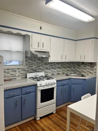 a kitchen with a sink a stove and cabinets