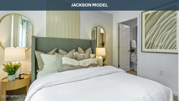 a bedroom with bed and mirror