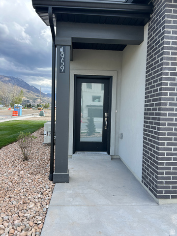 2003 South 1150 West, Unit 1040 Payson, UT 84651 - Photo 2 of 40 Modern exterior featuring a dark brick accent wall, a contrasting light stucco finish, and a dark-framed glass paneled entry door