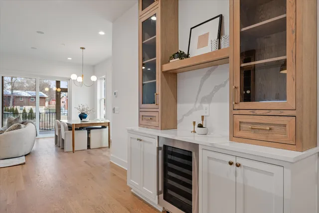 a living room with stainless steel appliances furniture a rug and a kitchen